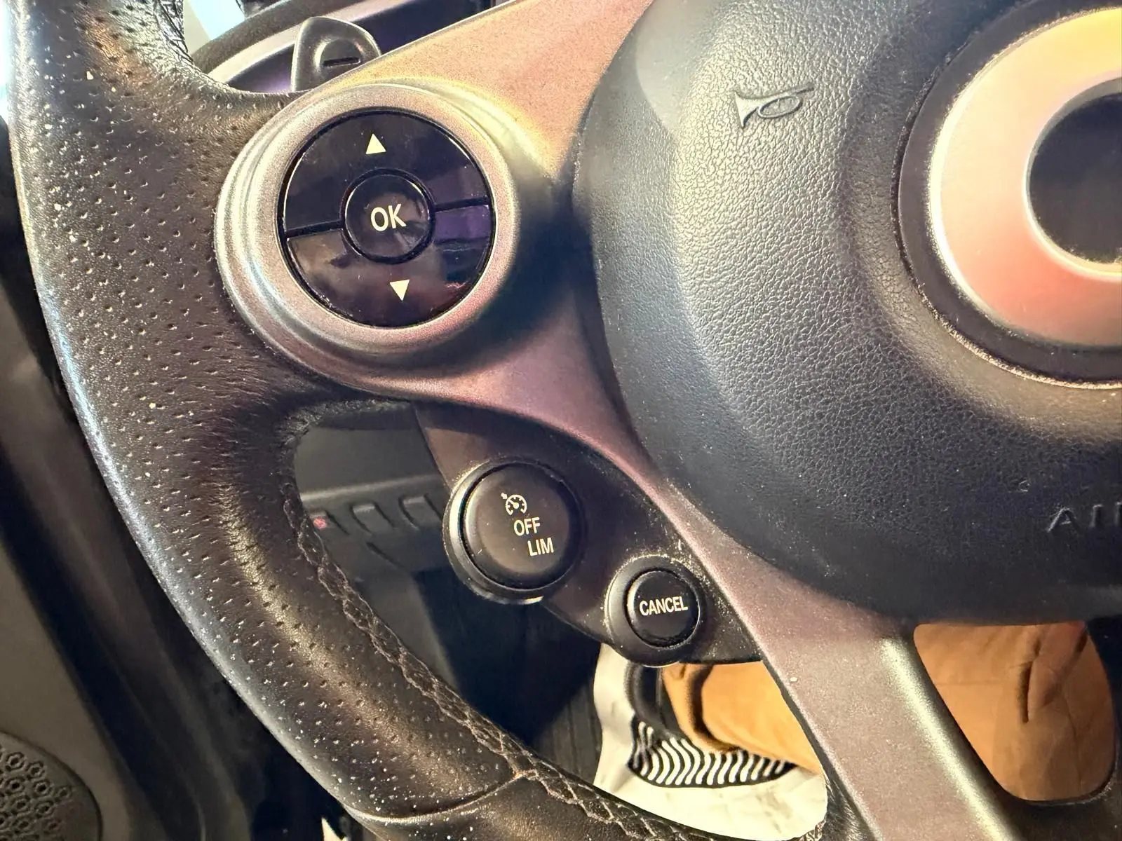 Gros plan sur le volant multifonctions noir de la Smart Fortwo Cabrio 2019 avec commandes de régulateur de vitesse.