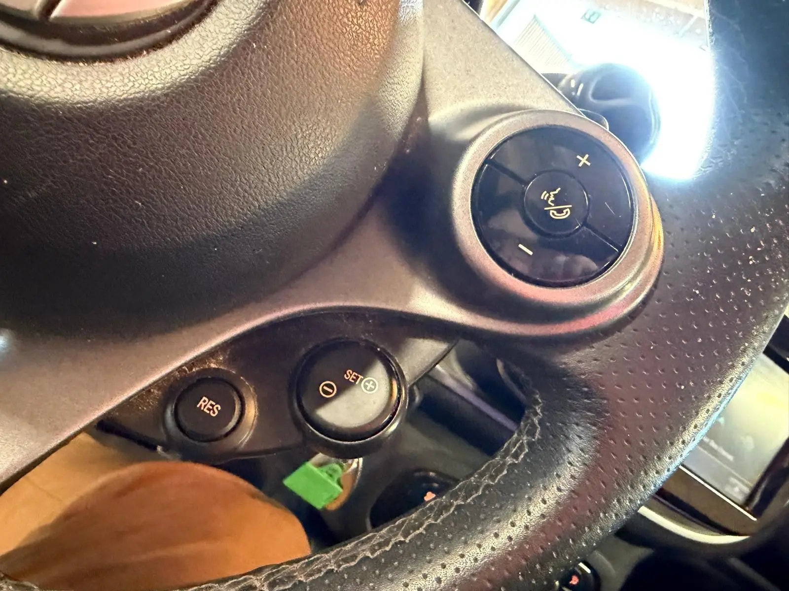 Gros plan sur le bouton de commande du volume sur le volant en cuir perforé noir d'une Smart Fortwo Cabrio 2019.