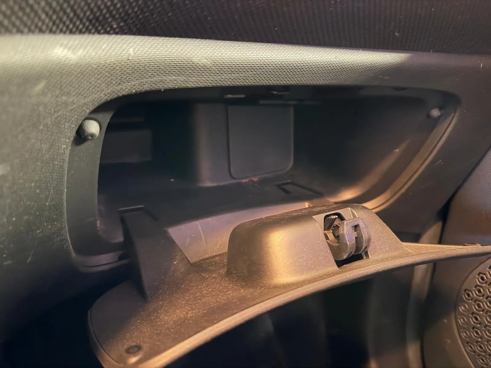 Gros plan sur la boîte à gants ouverte de la Smart Fortwo Cabrio noire, intérieur en plastique noir.