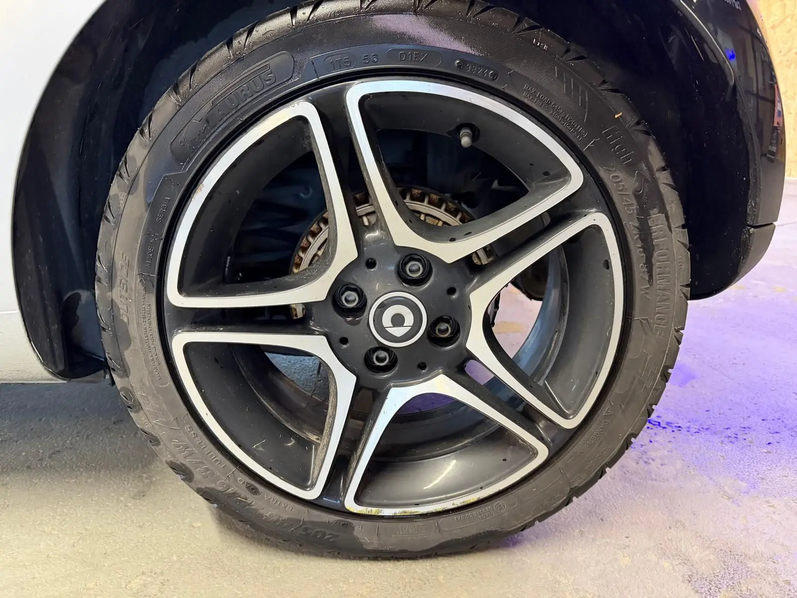 Gros plan sur la jante alu 16 pouces noire et argentée d'une Smart Fortwo Cabrio 2019, avec pneu visible.