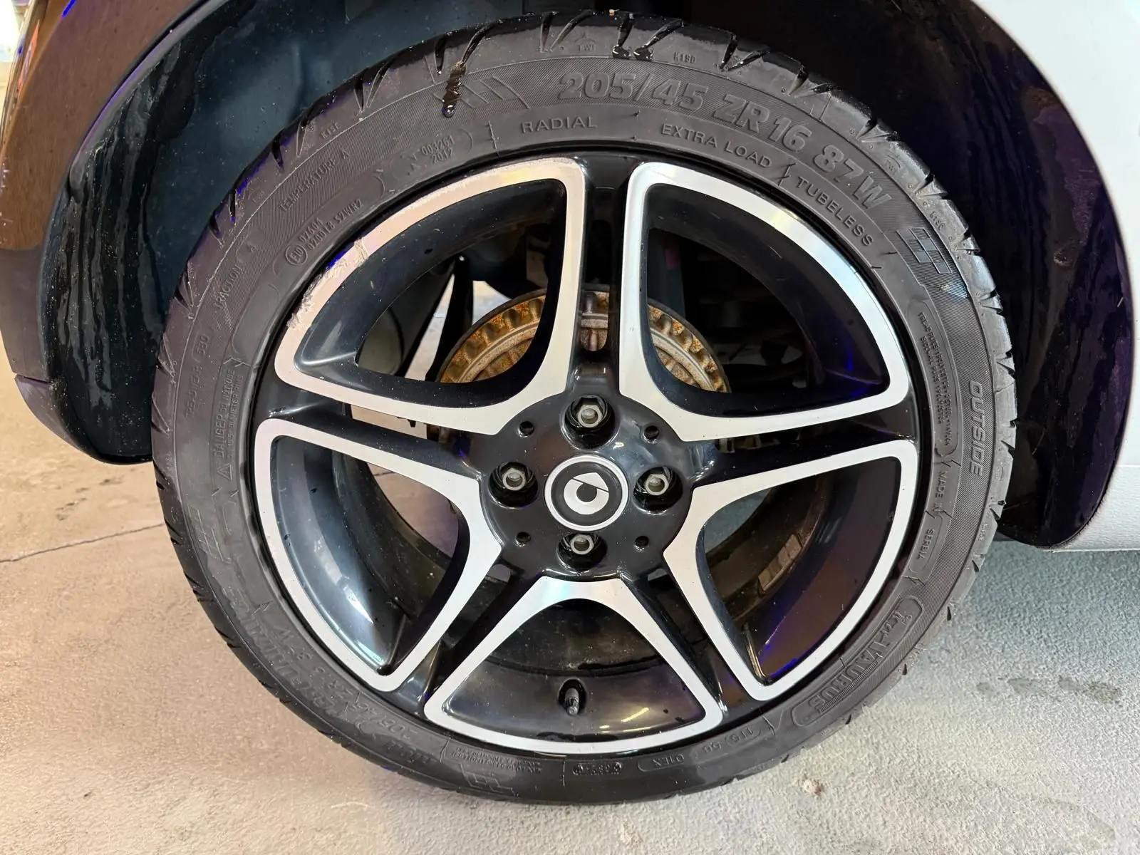 Gros plan sur la jante alu 16 pouces noire et argentée d’une Smart Fortwo Cabrio 2019, avec pneu visible.