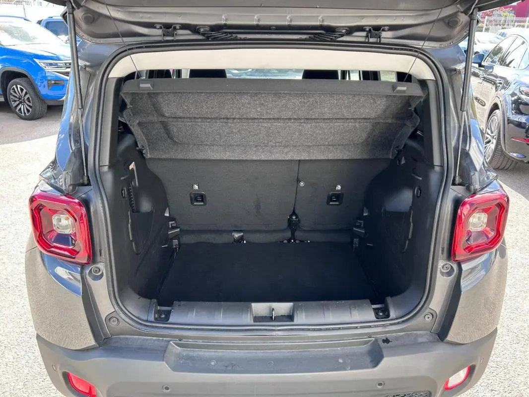 Coffre ouvert vu de l'arrière d'un Jeep Renegade bleu foncé 2023, avec banquette arrière et espace de chargement visible.