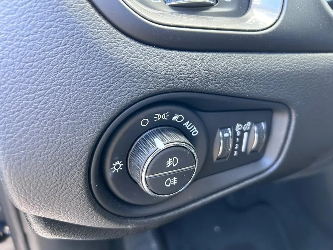 Gros plan sur la molette de réglage des phares et des feux antibrouillard dans l'habitacle du Jeep Renegade 2023.