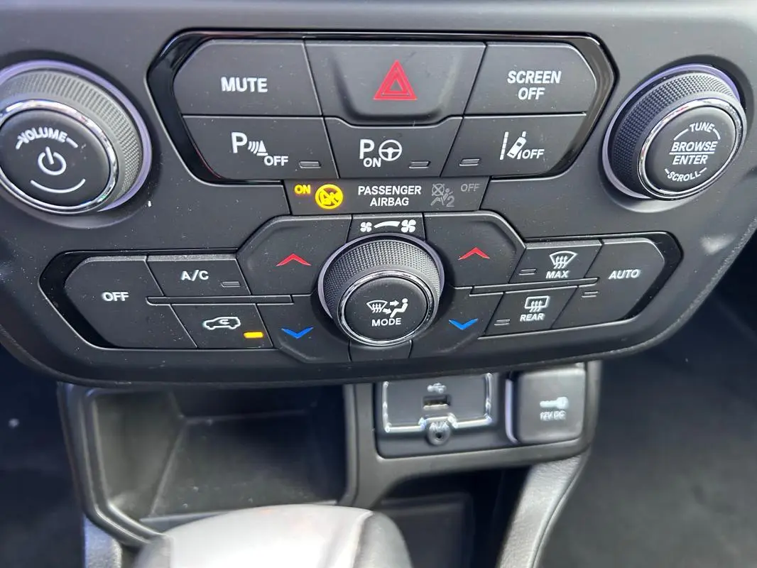 Gros plan sur la console centrale noire du Jeep Renegade 2023, avec commandes climatisation et boutons multifonctions.