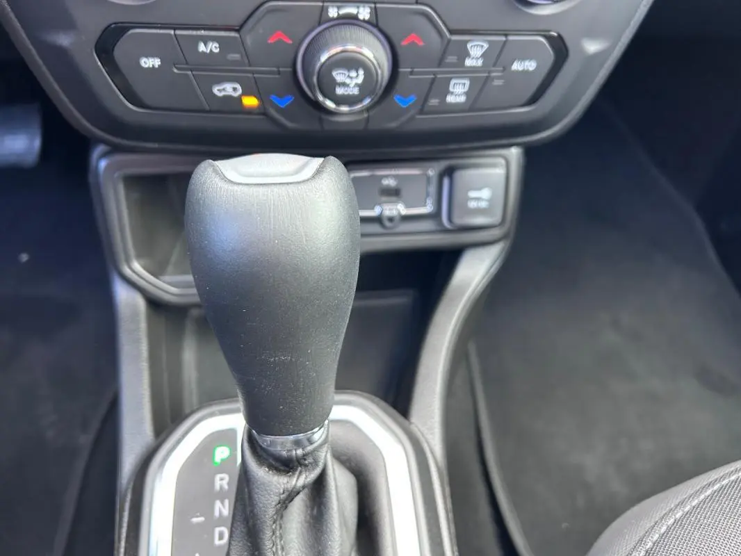 Gros plan sur le levier de vitesse automatique noir de la Jeep Renegade 2023 avec commandes de climatisation en arrière-plan.