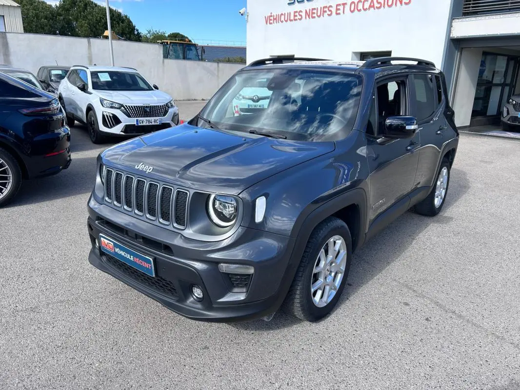 Jeep Renegade bleu foncé en 3/4 avant droit, avec barres de toit et jantes alliage 17 pouces visibles.