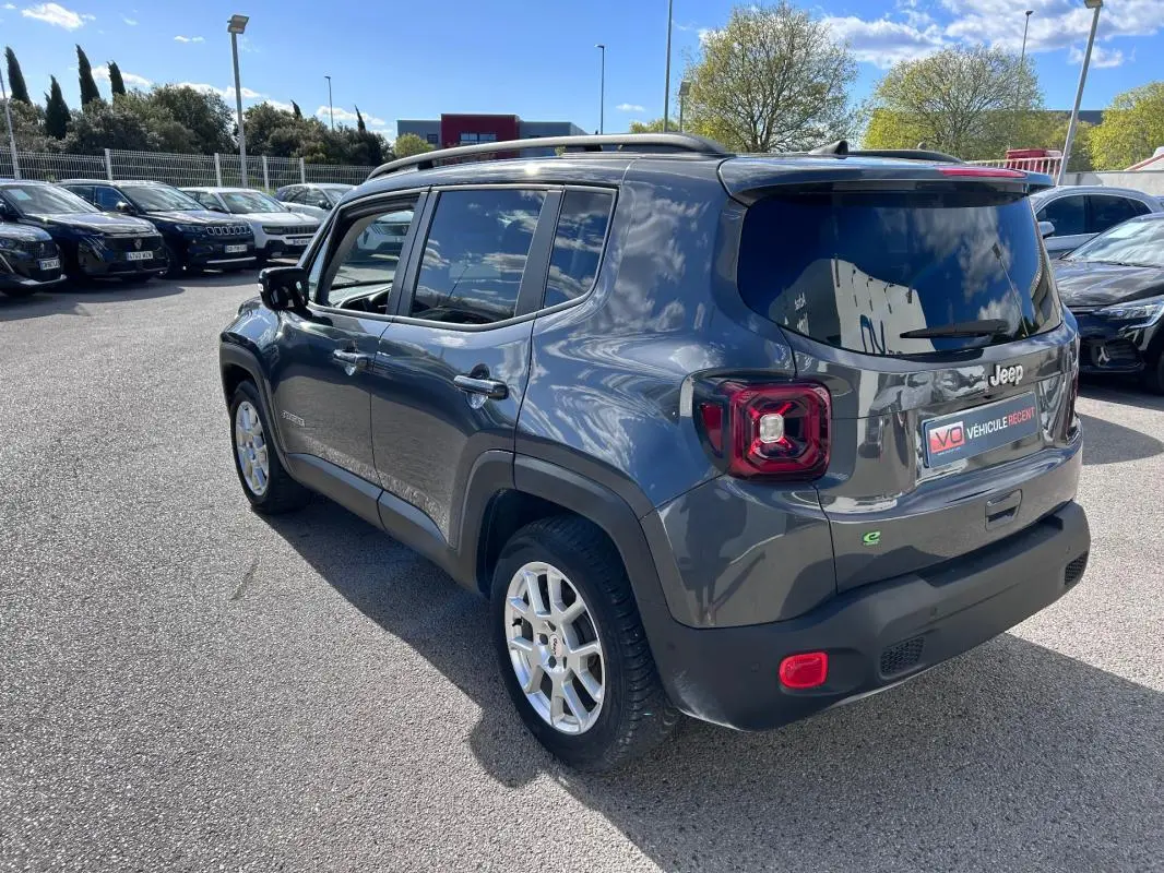 Vue 3/4 arrière droite d'un Jeep Renegade bleu foncé avec barres de toit et jantes alliage 17 pouces.