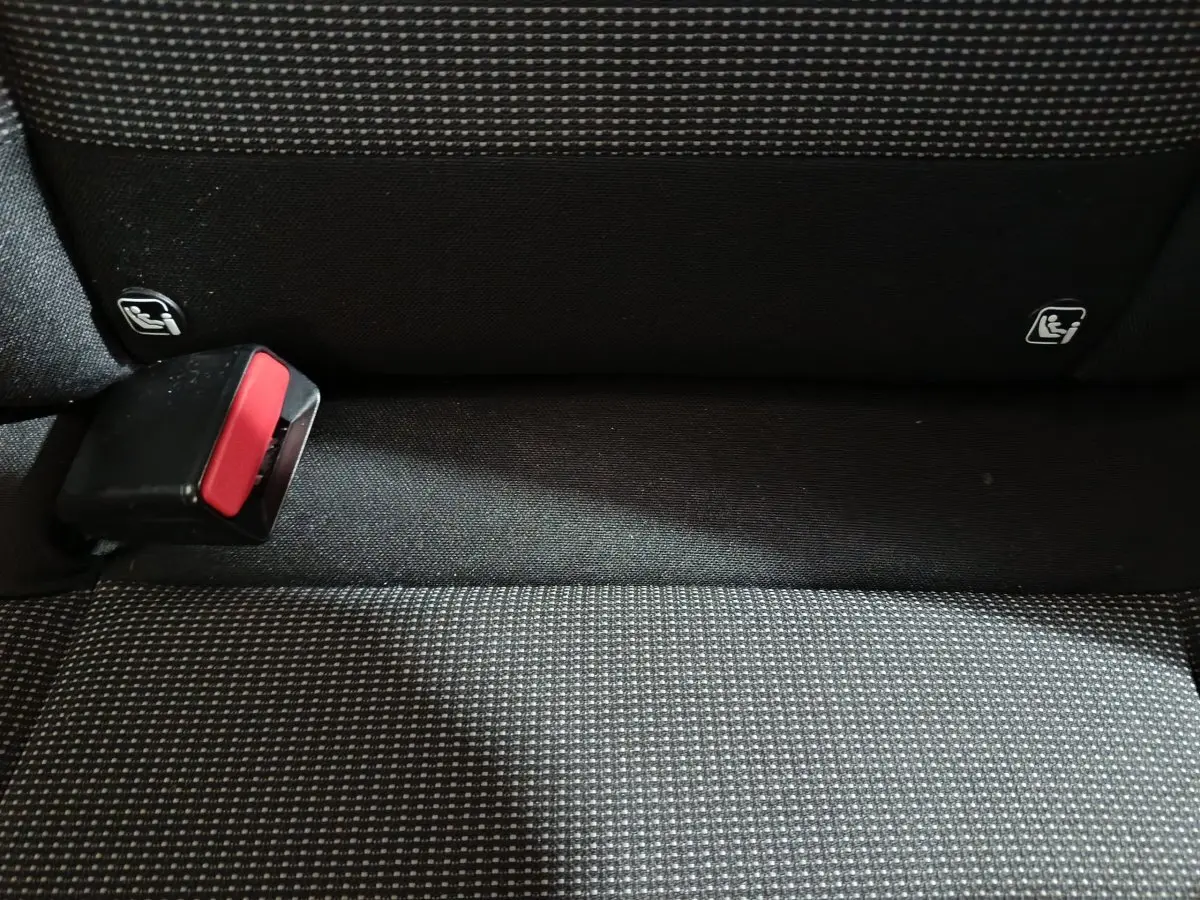 Gros plan sur la banquette arrière grise à motifs avec boucle de ceinture et fixations Isofix visibles.