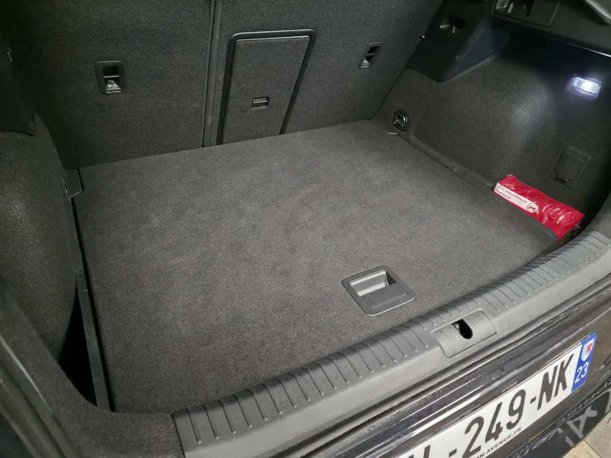 Vue intérieure du coffre spacieux et tapissé en gris foncé du CUPRA Formentor 2.0 TDI 2025, avec trappe centrale et kit de secours rouge.