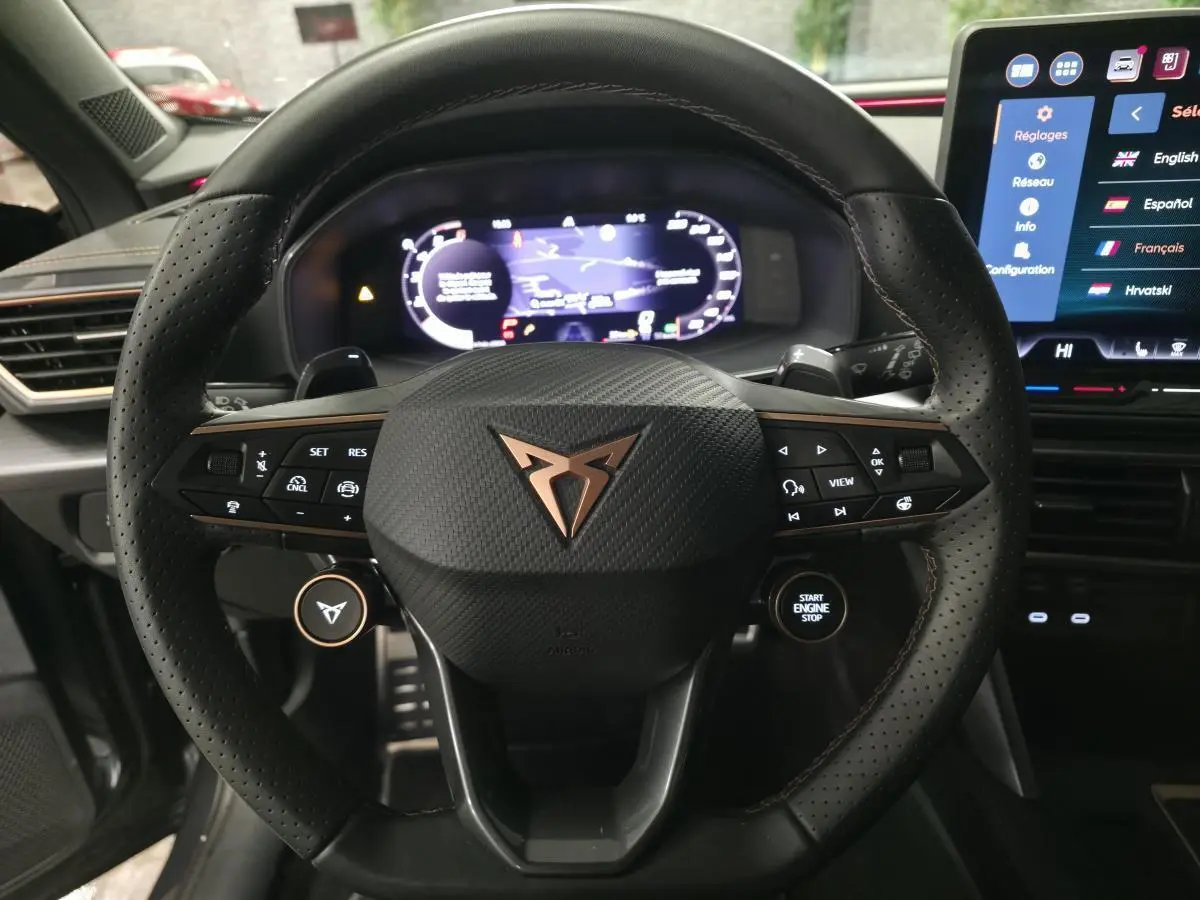 Volant cuir perforé noir avec logo CUPRA cuivré, tableau de bord digital et écran tactile central du Cupra Formentor 2025.