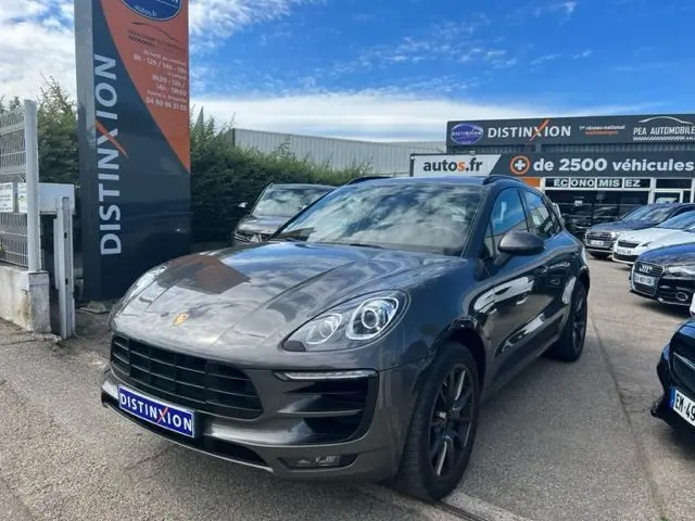 Porsche Macan gris 3/4 avant droit, version diesel 3.0 V6 de 2015, stationné devant un concessionnaire Distinxion.