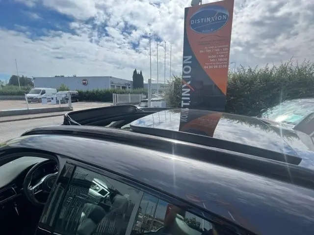 Vue plongeante sur le toit ouvrant ouvert d'un Porsche Macan gris diesel 2015, intérieur partiellement visible.