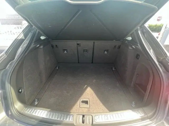 Coffre ouvert d'un Porsche Macan gris 2015, vue arrière montrant un espace de chargement propre et spacieux.