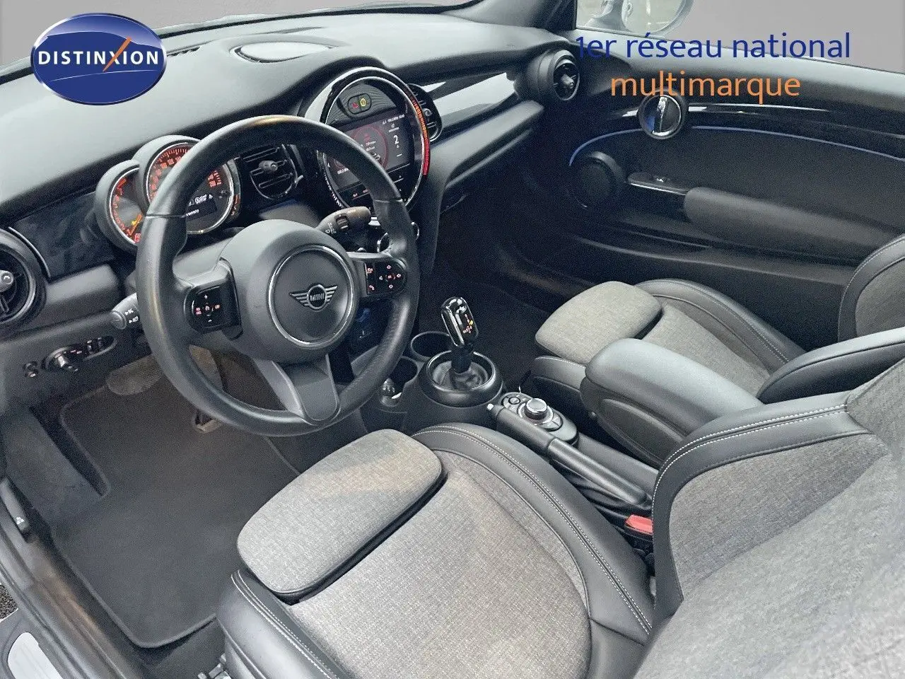 Intérieur de MINI Cabriolet F57 2023 vu côté conducteur, sièges gris clair avec cuir noir et tableau de bord moderne.