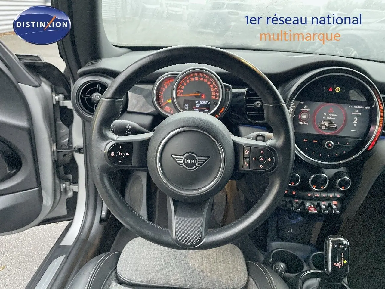 Vue intérieure centrée sur le volant et le tableau de bord d'une MINI Cabriolet Melting Silver 2023, avec boîte auto.