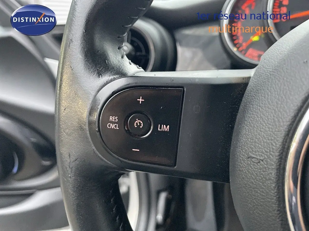 Gros plan sur la commande de régulateur de vitesse au volant en cuir noir du MINI Cabriolet Melting Silver 2023.