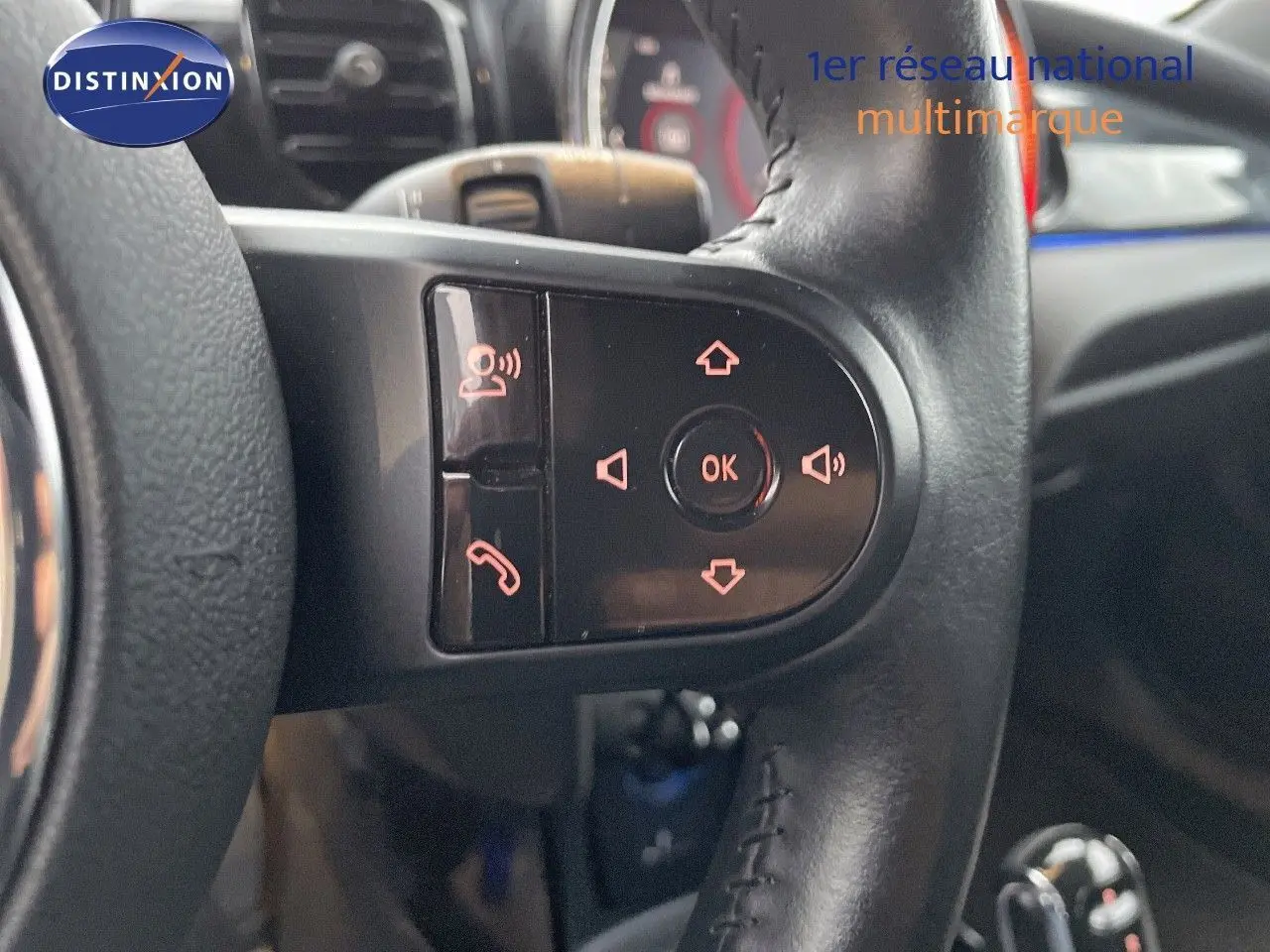 Gros plan sur les commandes au volant en cuir noir du MINI Cabriolet Melting Silver 2023, avec boutons multifonctions éclairés.