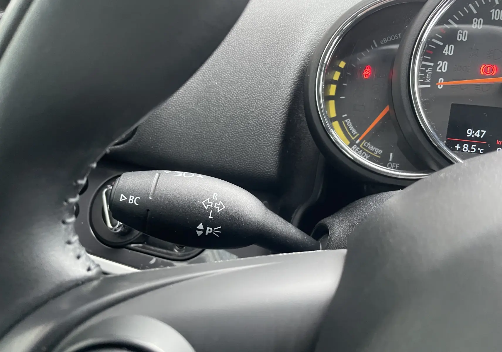 Gros plan sur le commodo de clignotant et le compteur du tableau de bord d'une MINI Countryman bleu Island Metal.