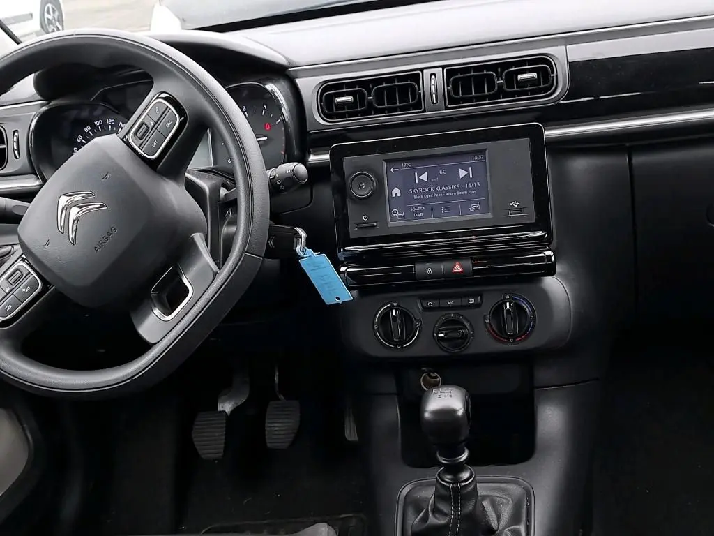 Vue intérieure côté conducteur du tableau de bord noir d'une Citroën C3 Société 2022, avec écran tactile et boîte manuelle.