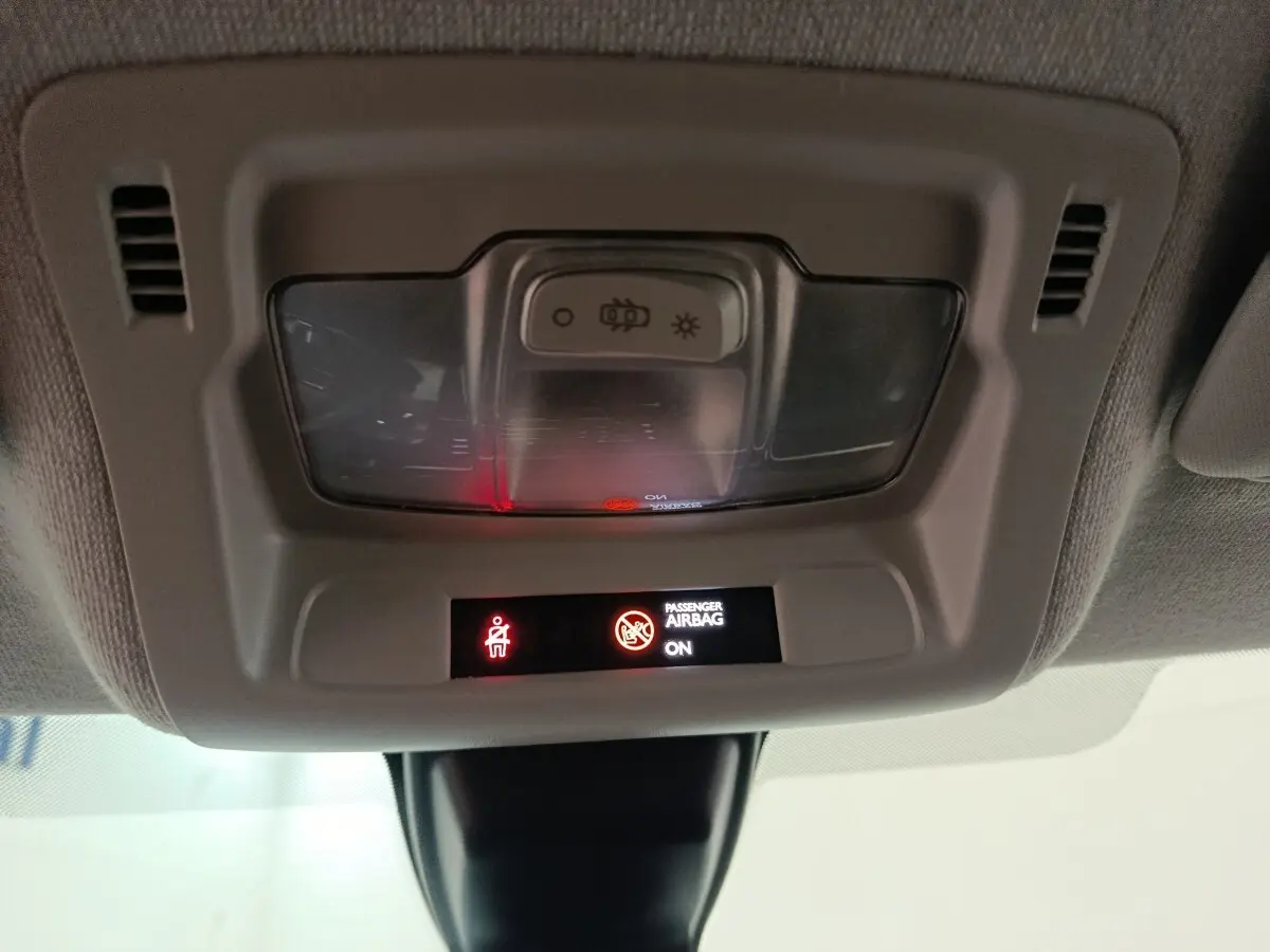 Vue intérieure du plafonnier de la Citroën C3 2024 avec indicateurs lumineux d'airbag passager activé.