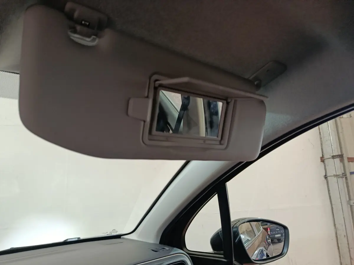 Vue intérieure côté conducteur du pare-soleil avec miroir ouvert, rétroviseur extérieur noir d'une Citroën C3 2024.
