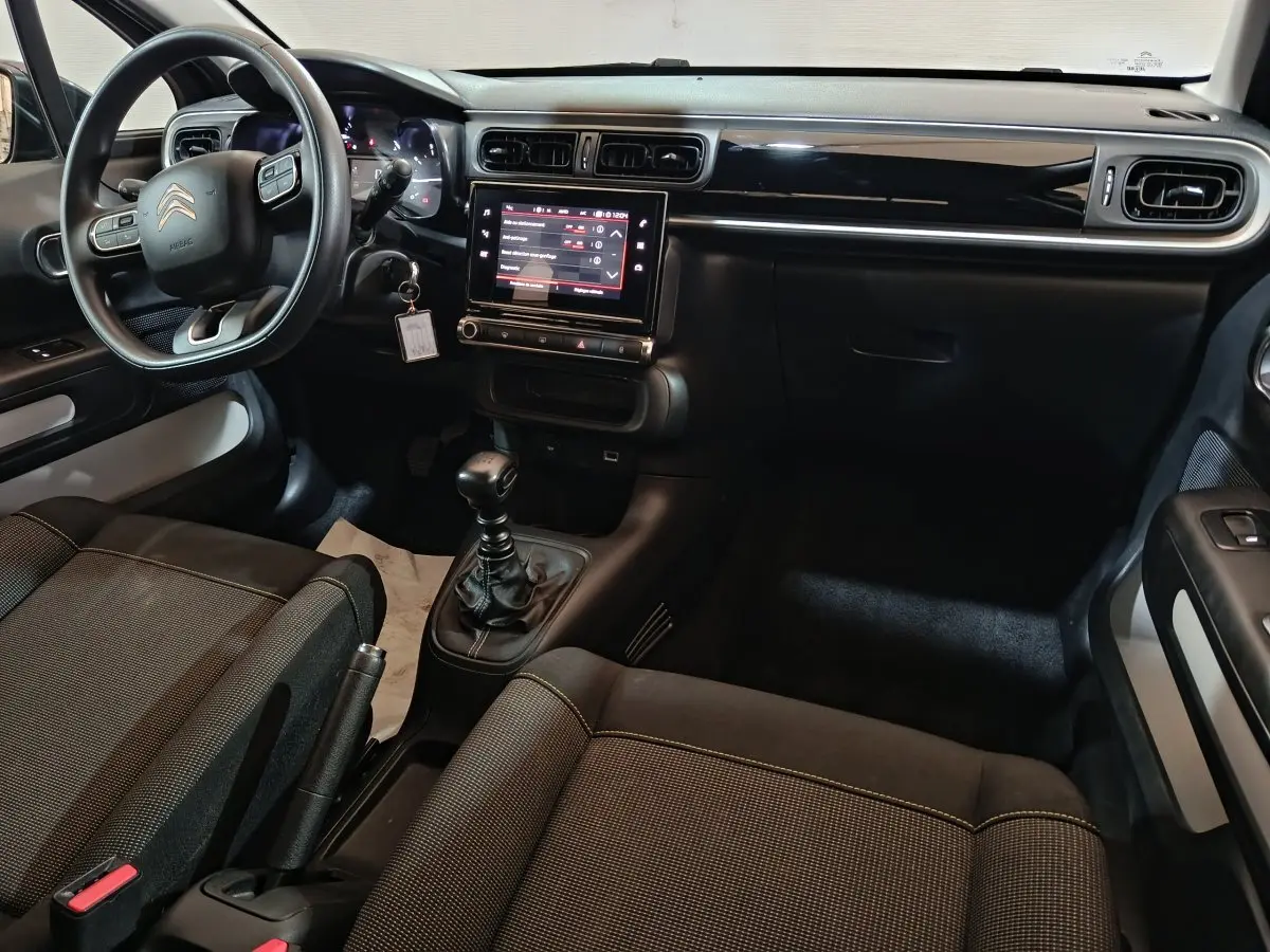 Vue intérieure côté conducteur de la Citroën C3 2024 noire, avec tableau de bord tactile et volant multifonctions.
