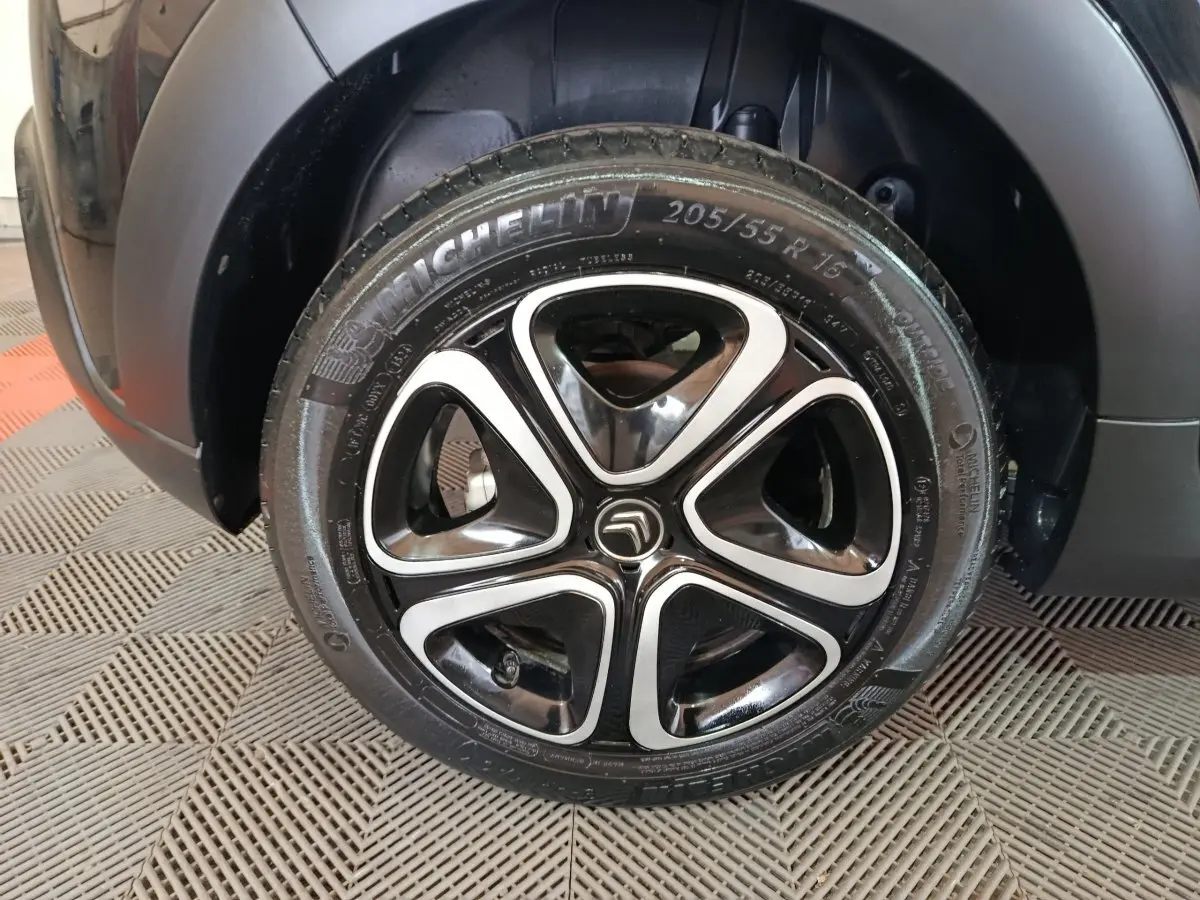 Gros plan sur la roue avant droite noire d'une Citroën C3 2024 avec jante alliage au design moderne.