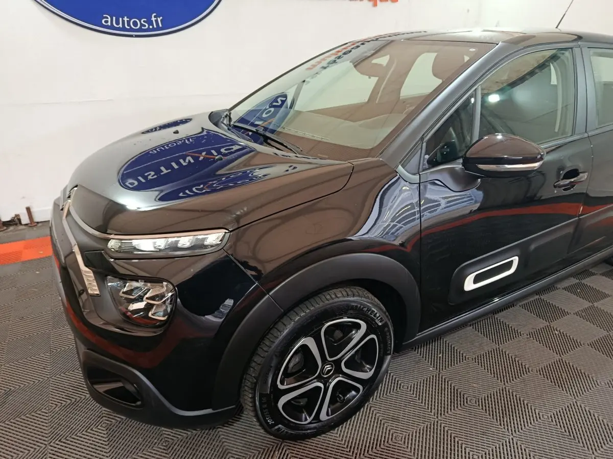Vue 3/4 avant droite d'une Citroën C3 noire 2024 avec phares LED et jantes distinctives au design moderne.