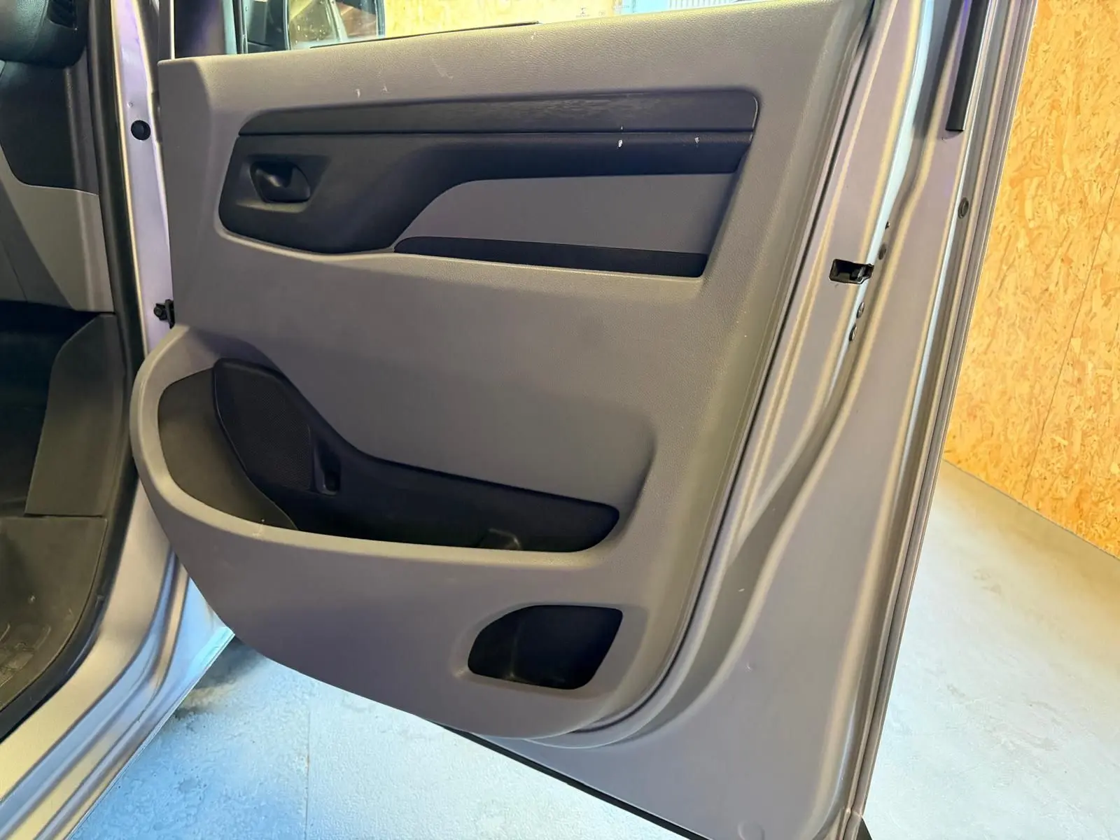 Gros plan sur la porte latérale droite grise du Citroën Jumpy 2.0 BlueHDi 180 EAT avec compartiments de rangement intégrés.
