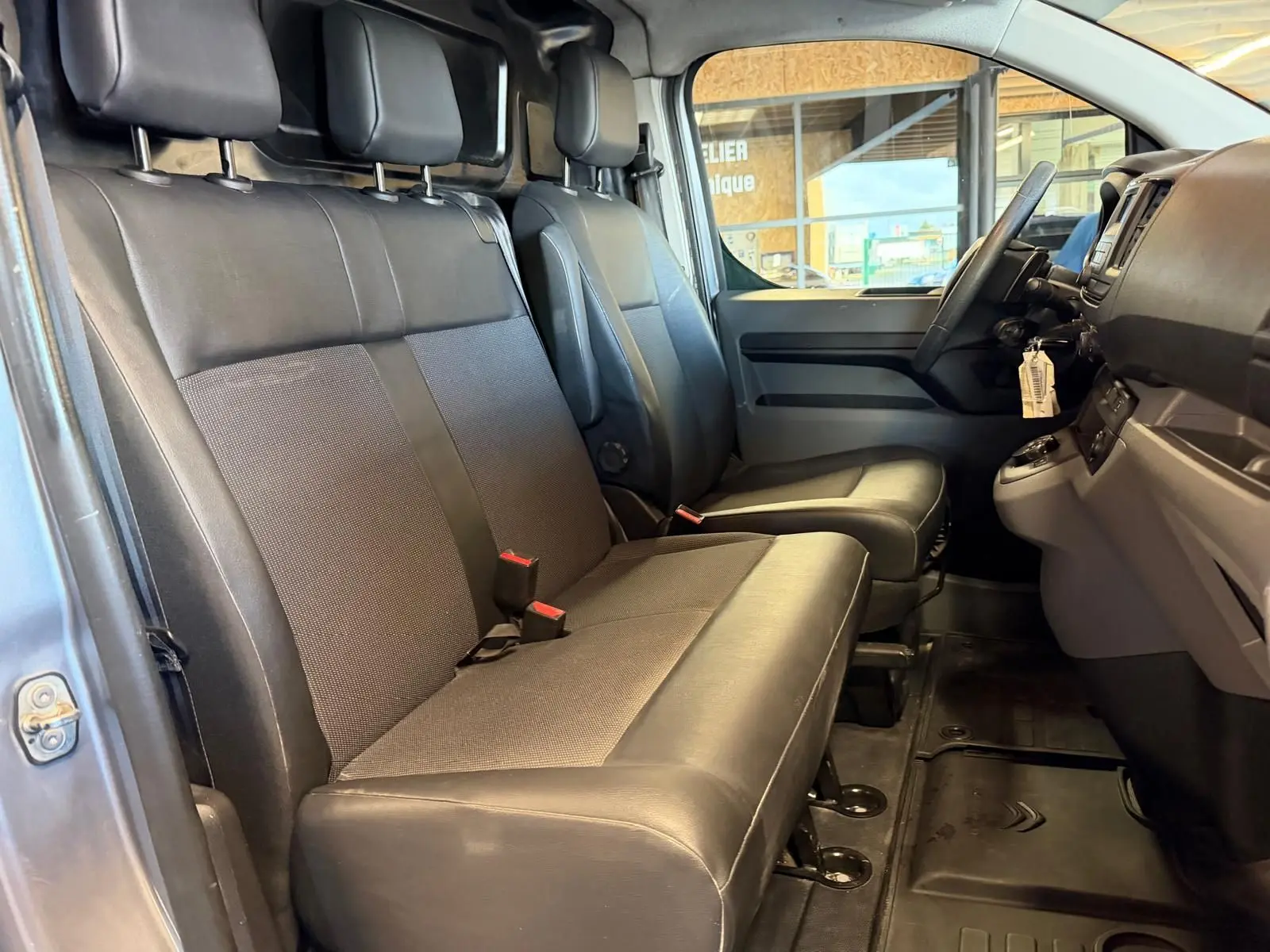 Vue intérieure côté conducteur du Citroën Jumpy 2.0 BlueHDi 180 2022, montrant les sièges avant en tissu noir.