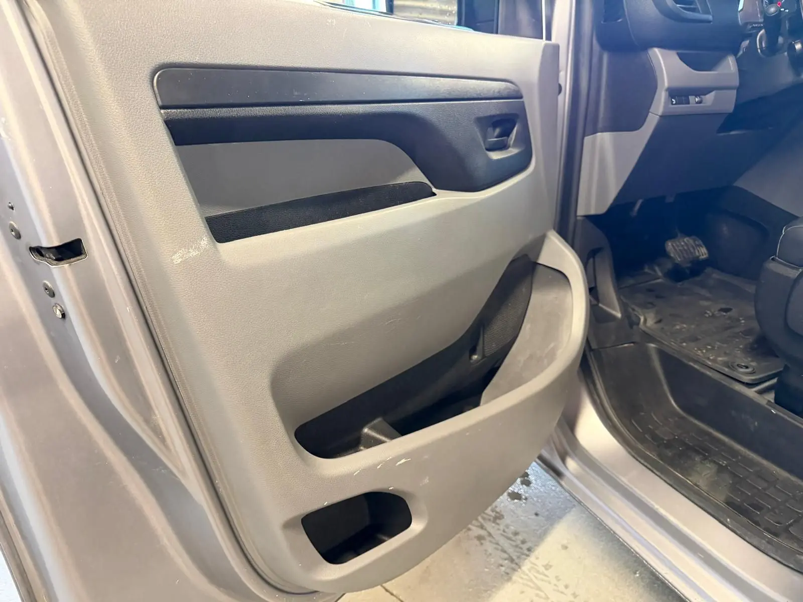 Détail de la porte avant gauche ouverte du Citroën Jumpy gris 2022, montrant la garniture intérieure et le seuil de porte.