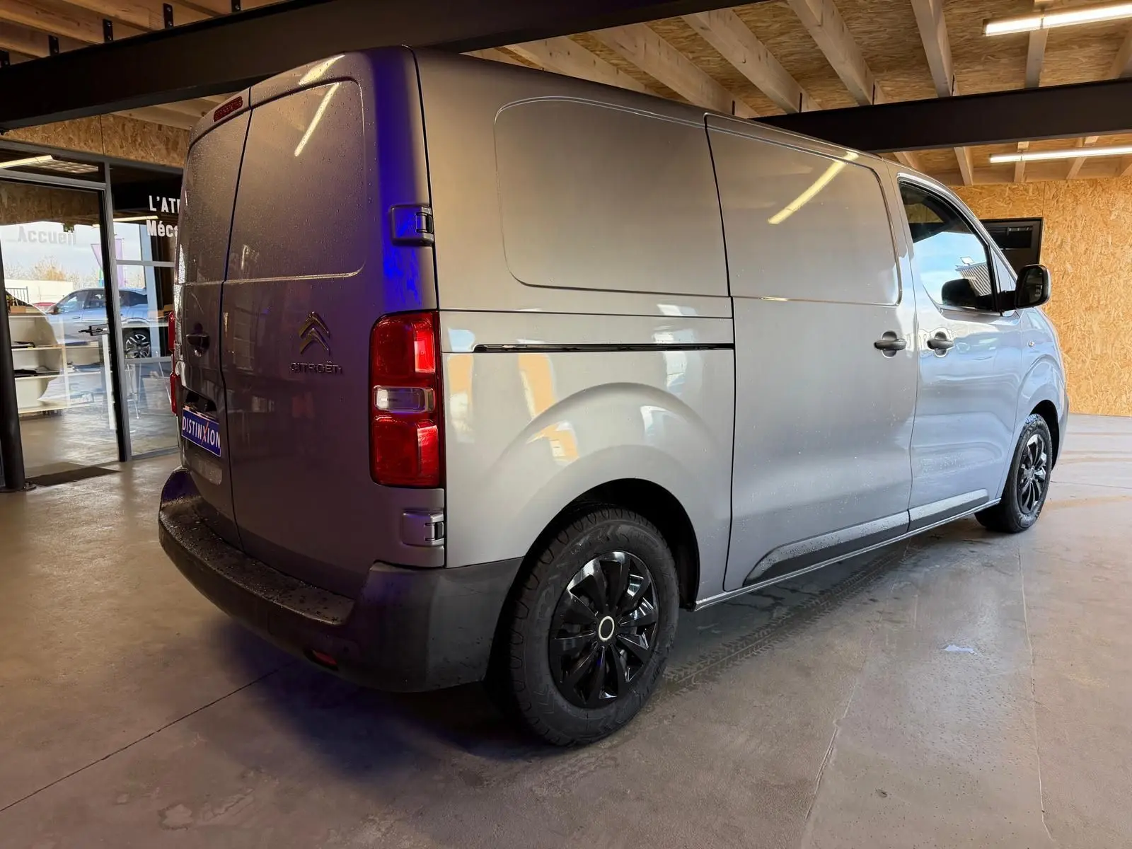 Vue 3/4 arrière droite du Citroën Jumpy gris métallisé 2022 avec portes battantes et jantes noires.