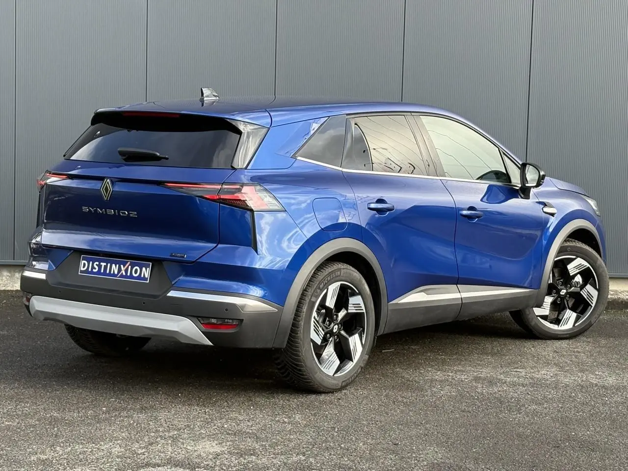 Vue 3/4 arrière droite du Renault SYMBIOZ bleu Iron avec jantes 18 pouces et hayon noir brillant.