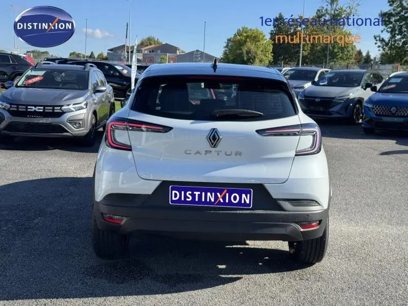 Vue arrière d'un Renault Captur blanc nacré 2025, avec feux LED fins et logo distinctif bien visible.