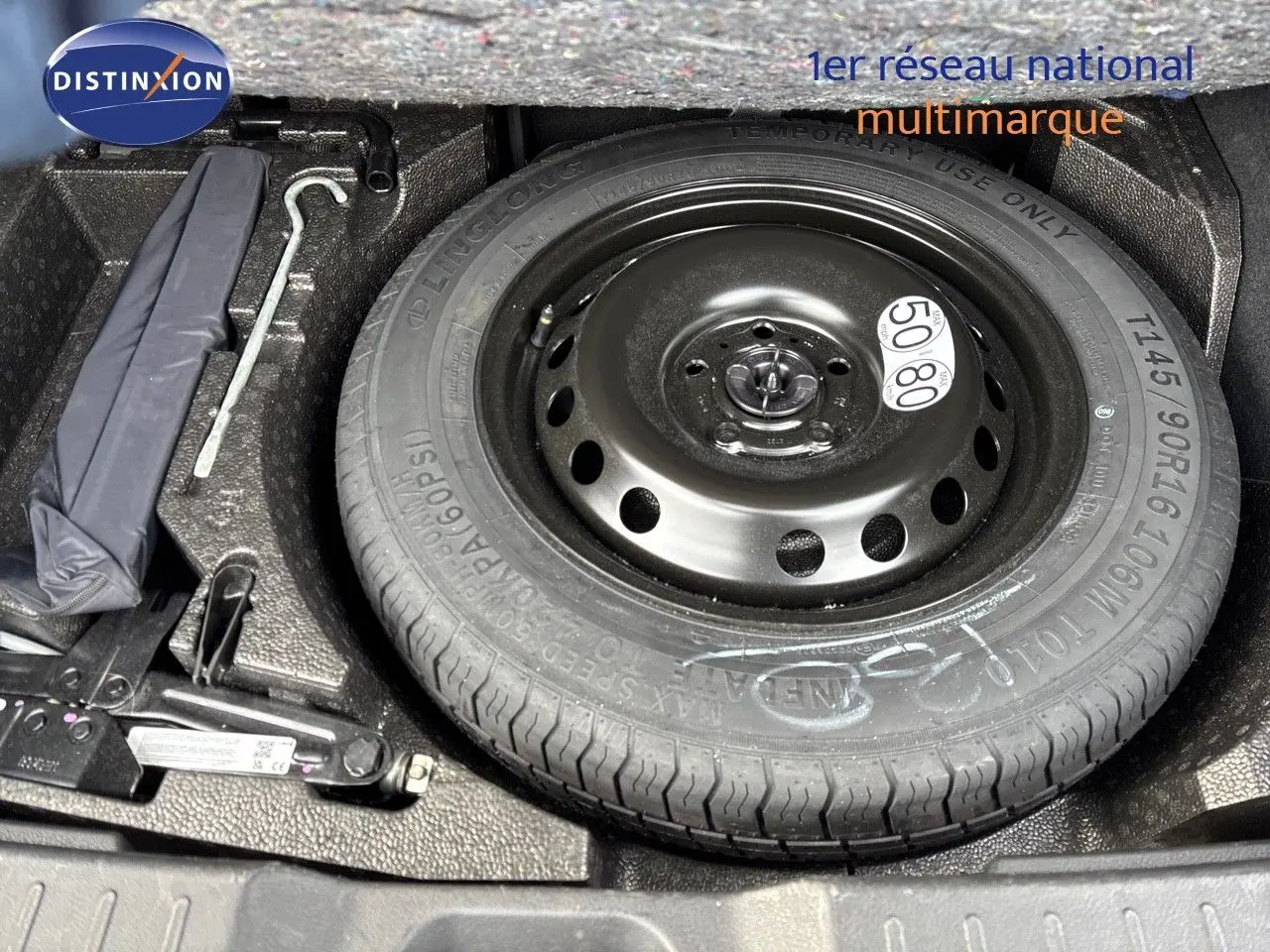 Roue de secours et outils de bord dans le coffre d'un Nissan Juke 1.6 HEV gris perle métal 2024.