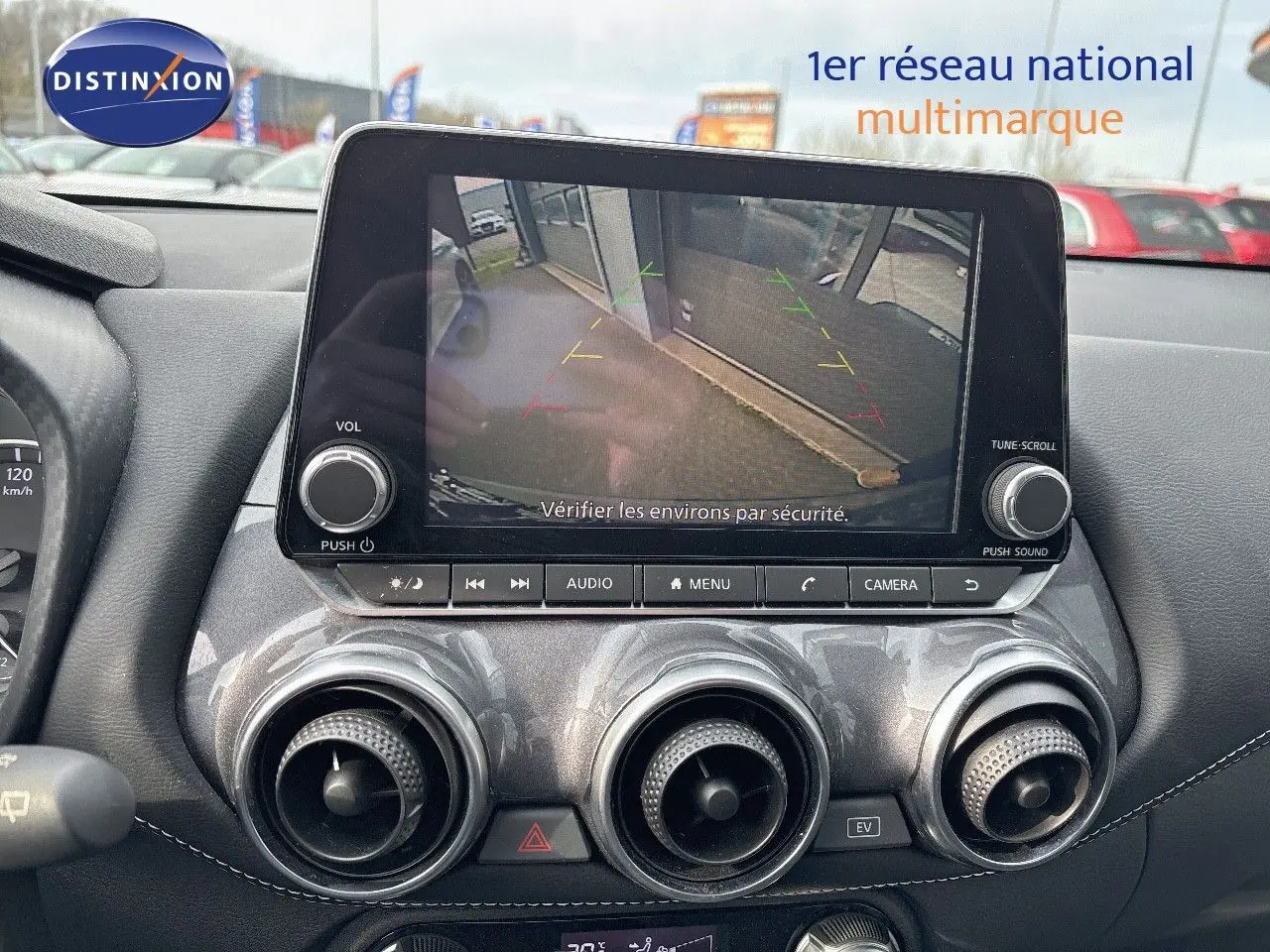 Vue intérieure du tableau de bord du Nissan Juke gris perle métal 2024, écran multimédia affichant la caméra de recul.