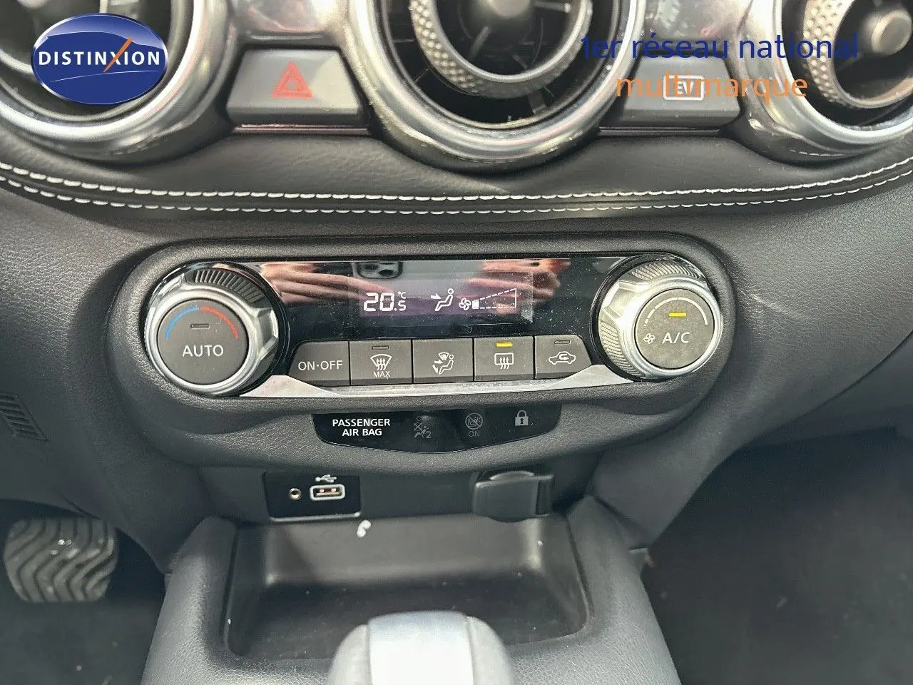 Tableau de bord du Nissan Juke 2024 gris perle, vue centrée sur la console de climatisation automatique avec affichage digital.