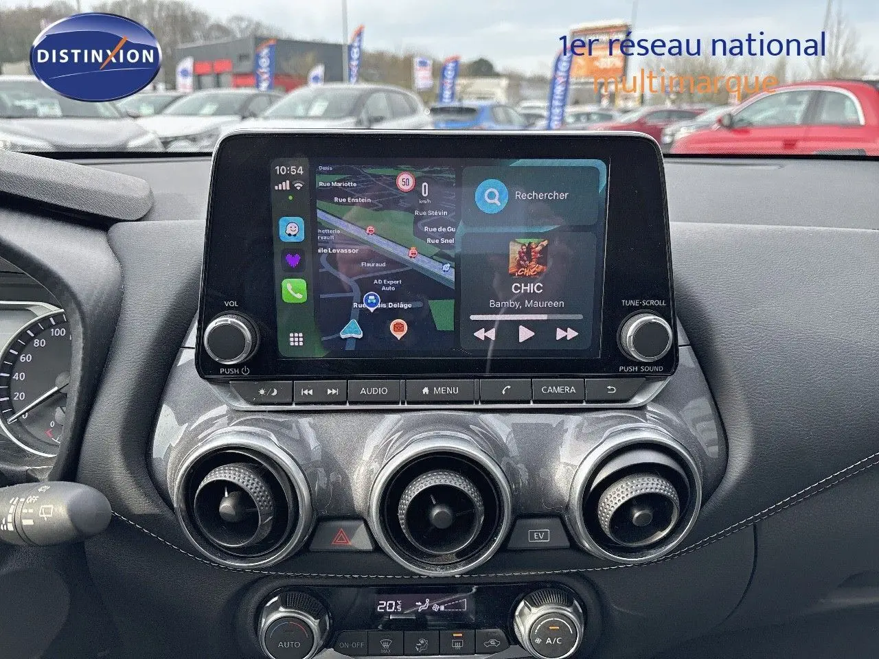 Tableau de bord du Nissan Juke 2024 gris perle, vue frontale centrée sur l'écran tactile et commandes de climatisation.