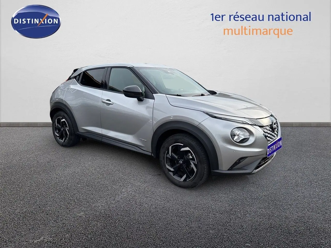 Nissan Juke gris perle métal vu de trois quarts avant droit, avec jantes noires et toit noir contrastant.