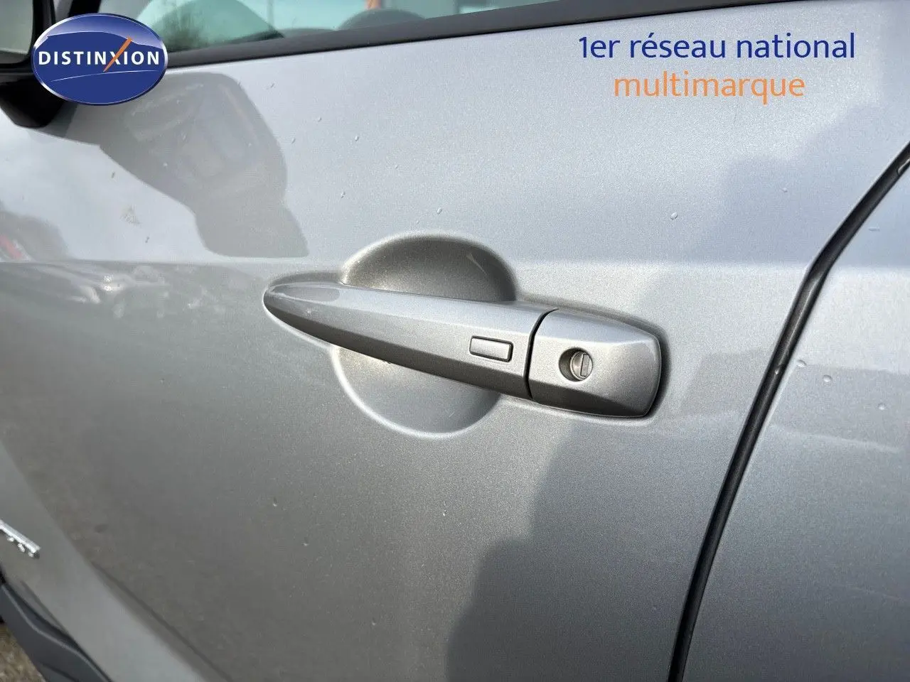 Poignée de porte côté gauche gris perle métal du Nissan Juke 1.6 HEV 143CH N-Connecta 2024 en gros plan.