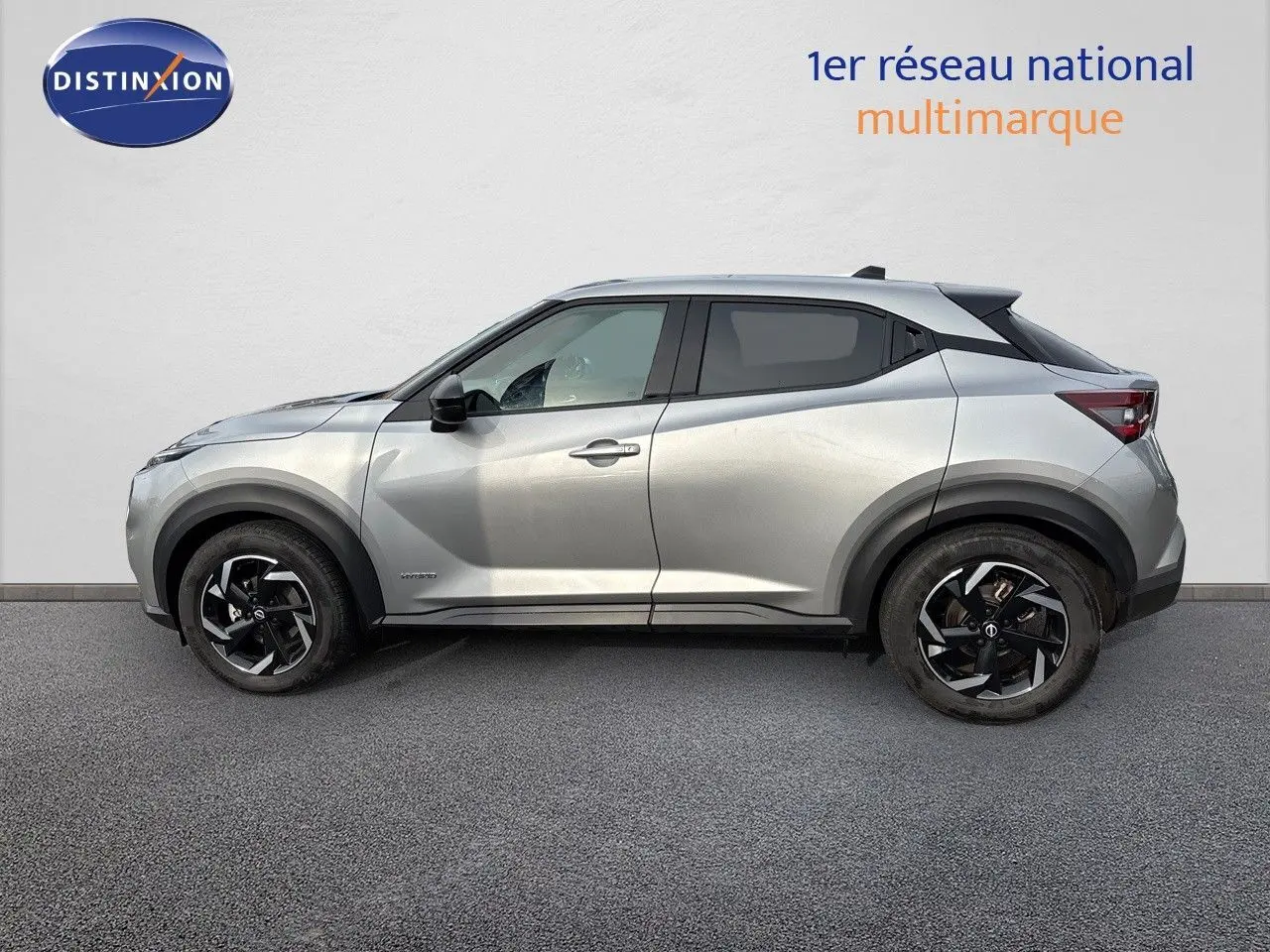 Profil côté gauche du Nissan Juke 1.6 HEV N-Connecta gris perle métal avec jantes noires biton, 2024.