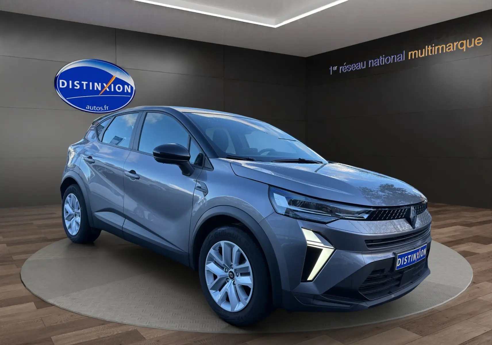 Renault Captur 2024 gris Cassiopée avec toit noir, vue 3/4 avant droit, feux LED en forme de V et calandre moderne.