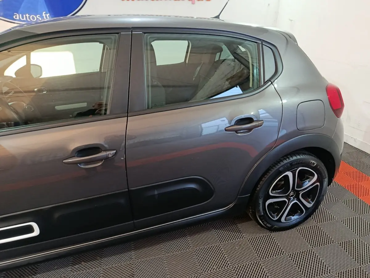 Vue latérale droite d'une Citroën C3 2024 gris foncé avec jantes alliage et protections de porte noires.