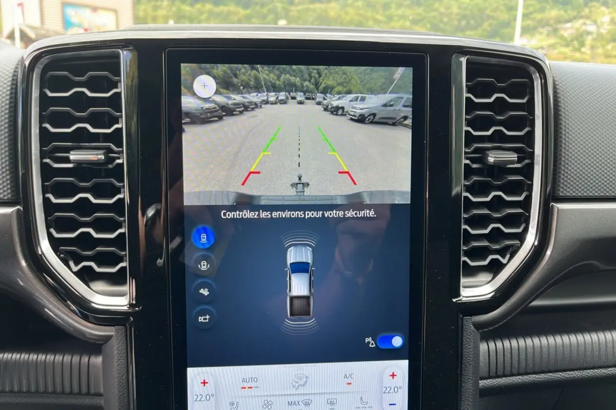 Écran central tactile du Ford Ranger gris carbone montrant la caméra de recul et l'interface de stationnement assisté.