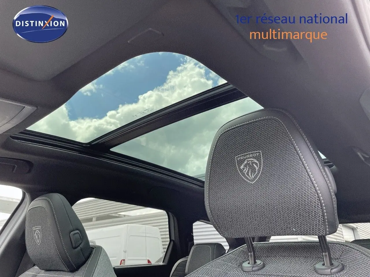 Intérieur du Peugeot 5008 Hybrid 2025 avec toit panoramique et appuie-tête avant brodé au logo Peugeot.