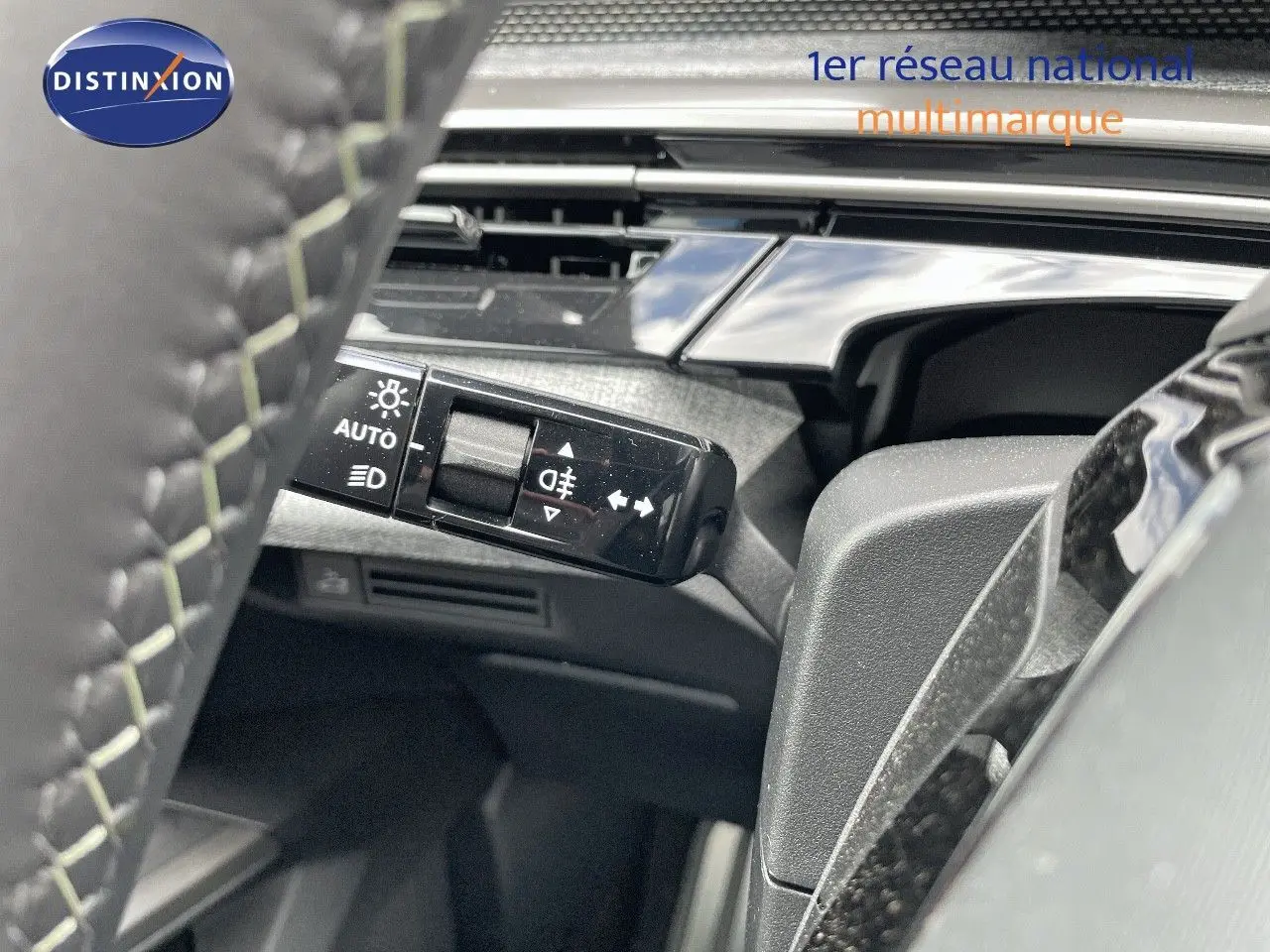 Gros plan sur la commande des feux à gauche du volant d’un Peugeot 5008 Hybrid blanc Okenite métal toit noir 2025.