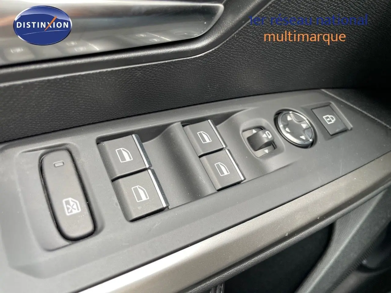 Gros plan sur les commandes de lève-vitres et rétroviseurs côté conducteur du Peugeot 5008 Hybrid blanc 2025.