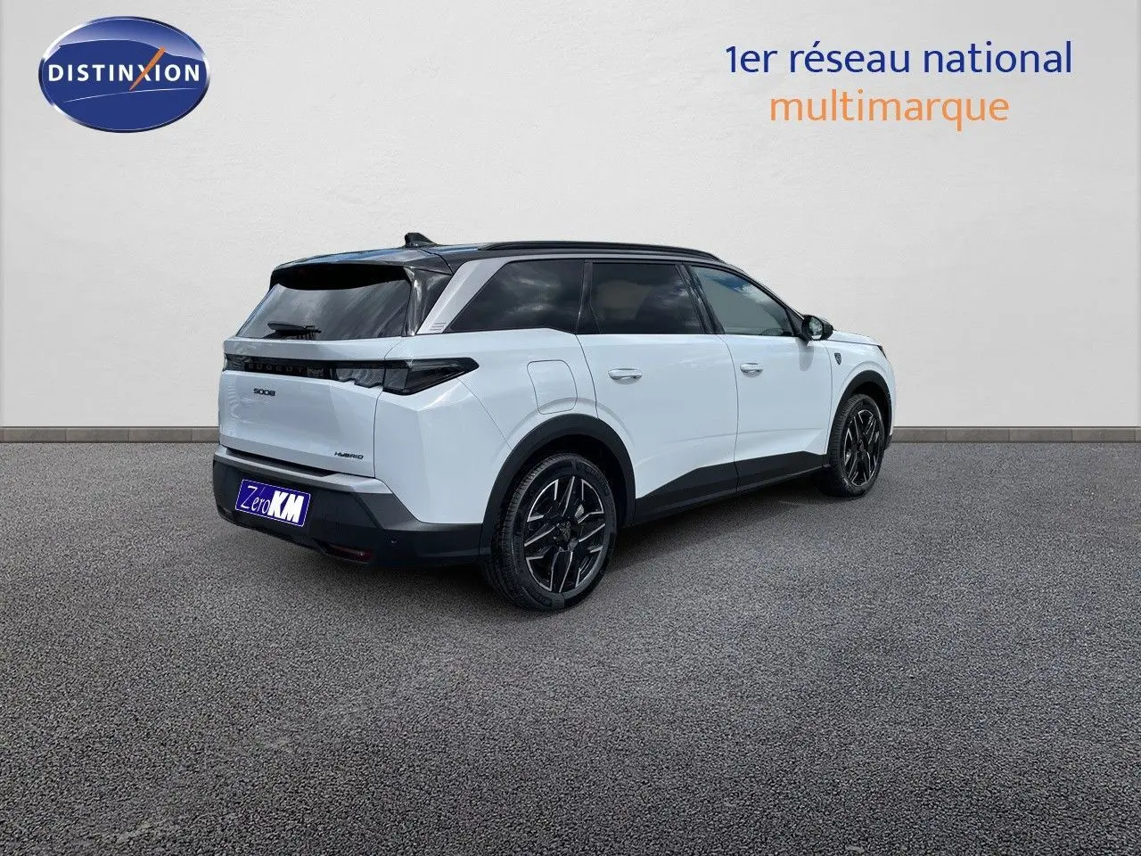 Vue 3/4 arrière droite du Peugeot 5008 hybride blanc Okenite avec toit noir et jantes noires distinctives.