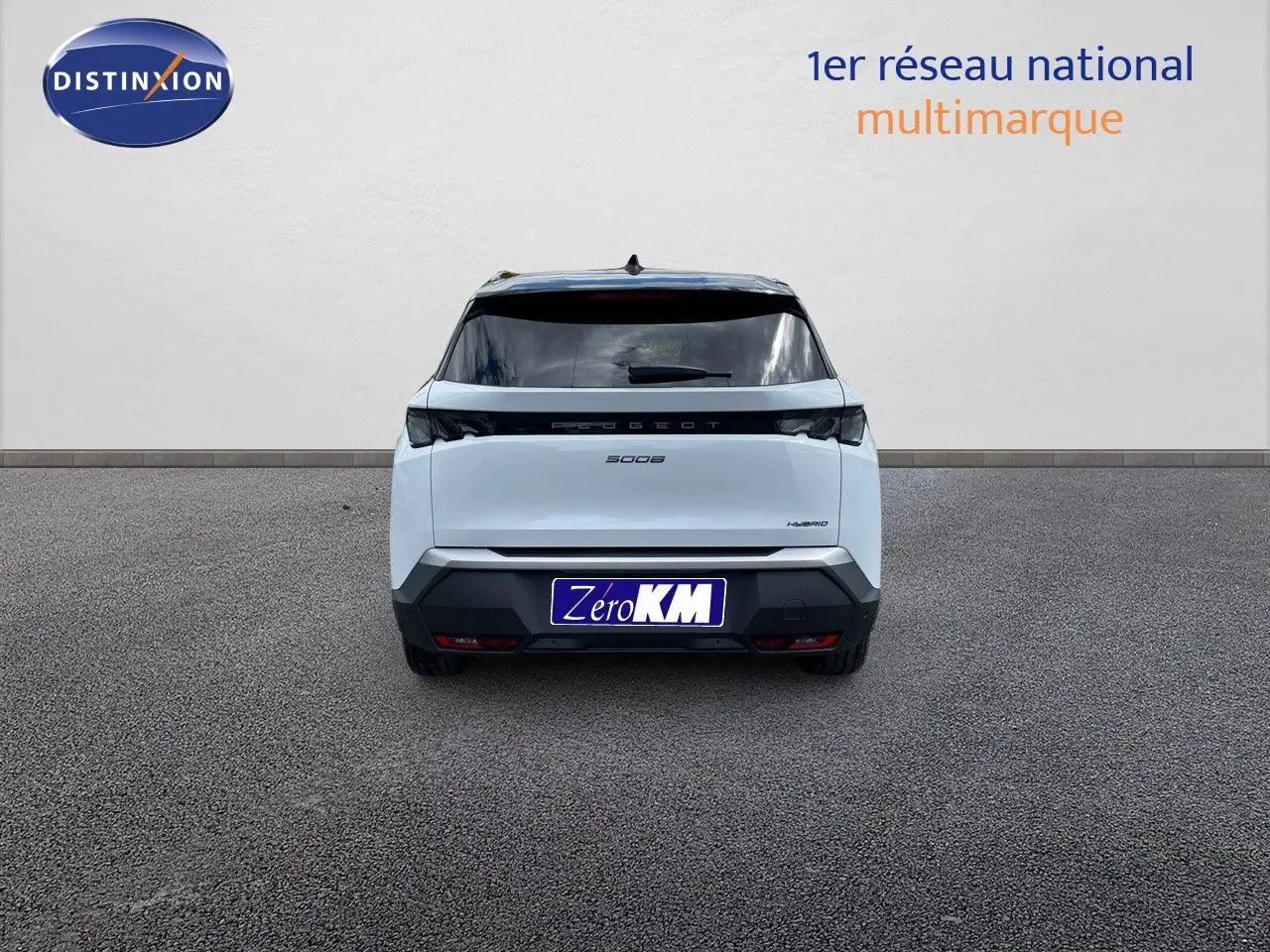 Vue arrière d'un Peugeot 5008 hybride blanc Okenite métal avec toit noir, immatriculé Zéro KM, sur sol gris.