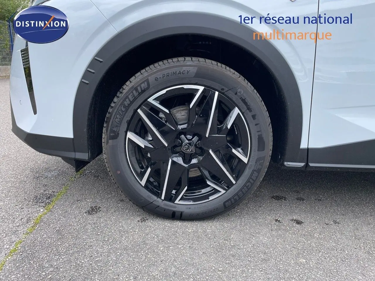 Gros plan sur la roue avant gauche du Peugeot 5008 blanc Okenite avec jante noire et détails argentés.